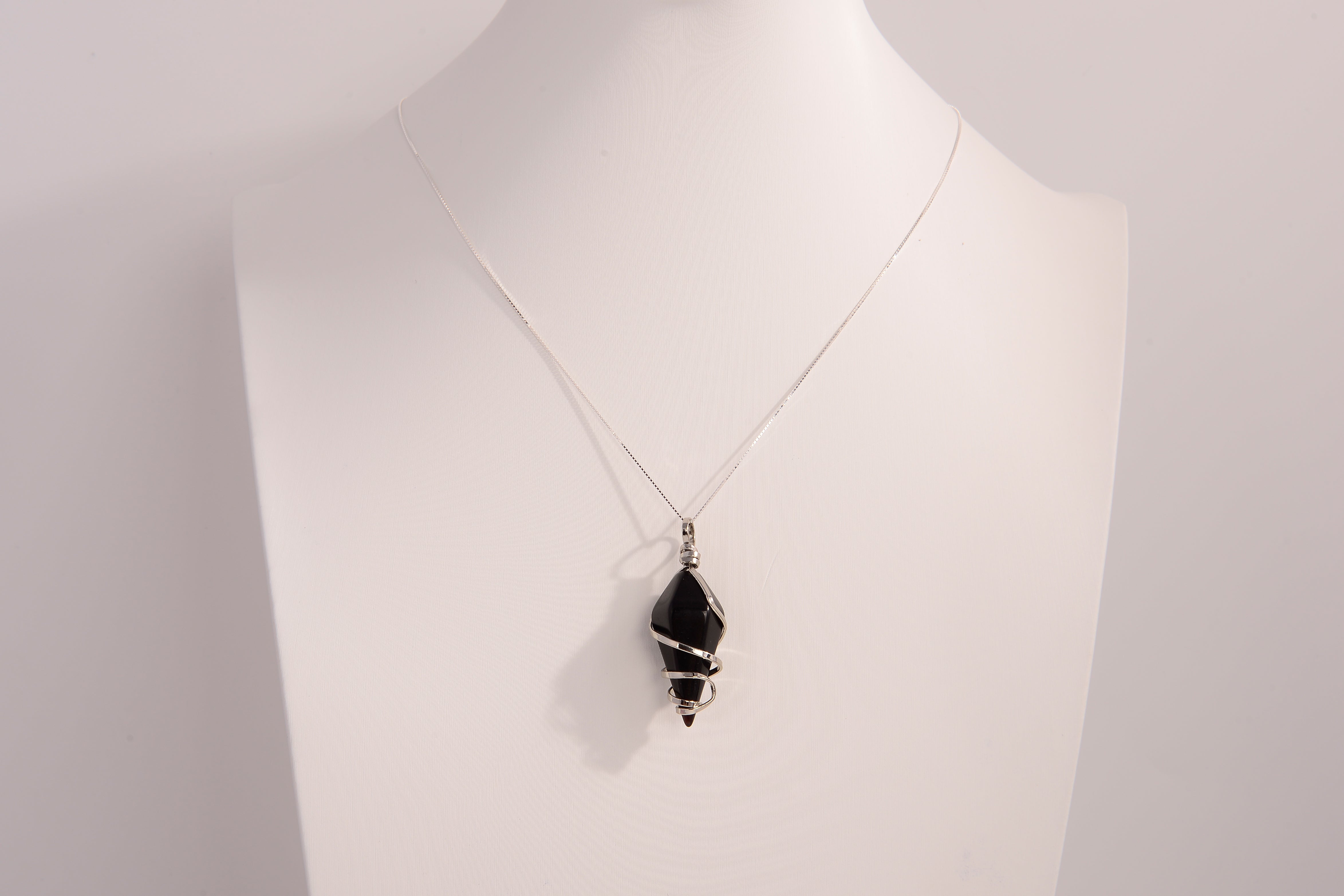 Black onyx spiral crystal pendant necklace with 925 sterling silver chain on white display bust