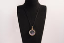 Raw Earth Crystals amethyst pendant with a crystal-encased design, featuring natural amethyst and gold-tone setting, enhancing intuition, calmness, and spiritual awareness.