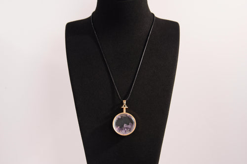 Raw Earth Crystals amethyst pendant with a crystal-encased design, featuring natural amethyst and gold-tone setting, enhancing intuition, calmness, and spiritual awareness.