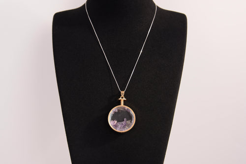 Raw Earth Crystals amethyst pendant with a crystal-encased design, featuring natural amethyst and gold-tone setting, enhancing intuition, calmness, and spiritual awareness.