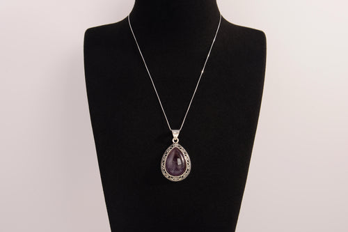 Raw Earth Crystals amethyst pendant with a teardrop-shaped design, featuring natural amethyst and an ornate silver-tone setting, promoting spiritual growth, calmness, and intuition.