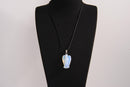 Raw Earth Crystals angel pendant crafted from carved opalite, featuring a soft, milky blue iridescence to promote calmness, emotional healing, and spiritual clarity.