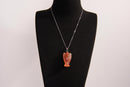 Raw Earth Crystals angel pendant crafted from carved red agate, featuring a warm, translucent design to promote courage, emotional strength, and grounding energy.