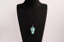 Raw Earth Crystals angel pendant crafted from carved turquoise, featuring a vibrant blue-green hue with natural matrix patterns to promote communication, protection, and emotional balance.