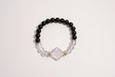 Raw Earth Crystals black onyx and clear quartz bracelet with silver accent, crafted from natural crystals, promotes clarity, protection, and spiritual alignment.