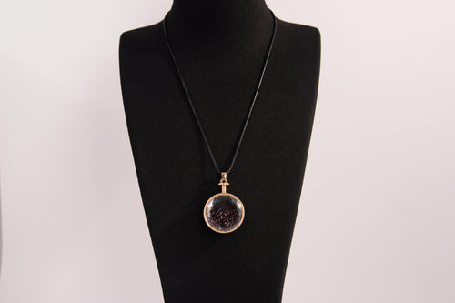 Raw Earth Crystals garnet pendant with a crystal-encased design, featuring natural garnet and gold-tone setting, promoting passion, vitality, and emotional strength.
