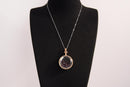 Raw Earth Crystals garnet pendant with a crystal-encased design, featuring natural garnet and gold-tone setting, promoting passion, vitality, and emotional strength.
