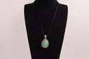 Raw Earth Crystals green aventurine pendant with a teardrop-shaped design, featuring natural green aventurine and an ornate silver-tone setting, promoting prosperity, luck, and emotional balance.