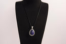 Raw Earth Crystals lapis lazuli pendant with a teardrop-shaped design, featuring natural lapis lazuli and an ornate silver-tone setting, promoting wisdom, truth, and spiritual insight.