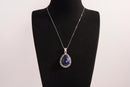 Raw Earth Crystals lapis lazuli pendant with a teardrop-shaped design, featuring natural lapis lazuli and an ornate silver-tone setting, promoting wisdom, truth, and spiritual insight.