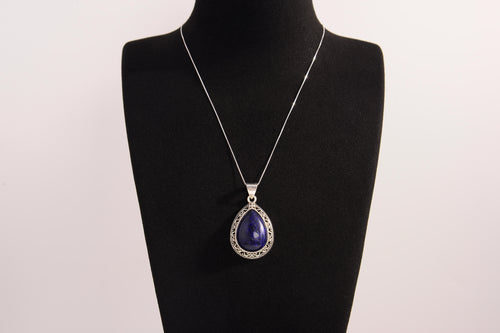 Raw Earth Crystals lapis lazuli pendant with a teardrop-shaped design, featuring natural lapis lazuli and an ornate silver-tone setting, promoting wisdom, truth, and spiritual insight.