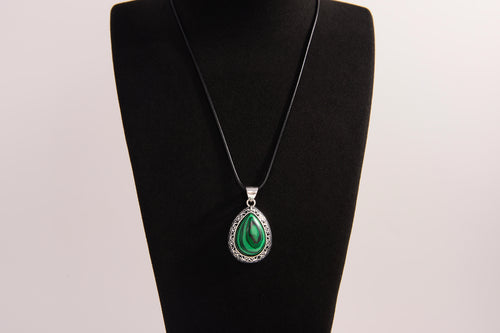 Raw Earth Crystals malachite pendant with a teardrop-shaped design, featuring natural malachite and an ornate silver-tone setting, promoting transformation, abundance, and emotional healing.