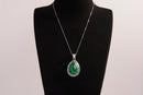 Raw Earth Crystals malachite pendant with a teardrop-shaped design, featuring natural malachite and an ornate silver-tone setting, promoting transformation, abundance, and emotional healing.