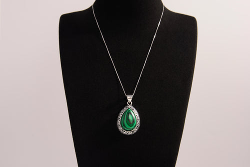 Raw Earth Crystals malachite pendant with a teardrop-shaped design, featuring natural malachite and an ornate silver-tone setting, promoting transformation, abundance, and emotional healing.