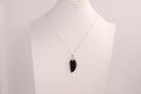 Raw Earth Crystals obsidian angel wing pendant, featuring a polished black obsidian stone carved into an elegant wing shape and set on a silver-tone chain, promoting protection, grounding, and spiritual connection.