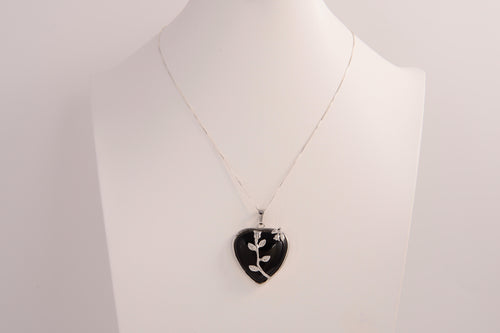 Raw Earth Crystals obsidian heart pendant with an elegant rose design, featuring a sleek black obsidian stone and a silver-tone vine with leaves, promoting protection, grounding, and emotional strength.