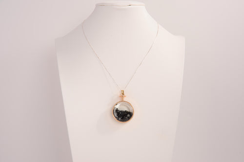 Raw Earth Crystals obsidian pendant with a crystal-encased design, featuring natural obsidian and gold-tone setting, promoting protection, grounding, and emotional balance.