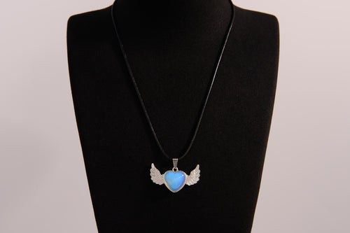 Raw Earth Crystals opalite heart with wings necklace, featuring a luminous blue heart-shaped stone adorned with delicate angelic wings, designed to enhance emotional healing, promote inner peace, and inspire spiritual connection.