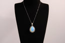 Raw Earth Crystals opalite pendant with a teardrop-shaped design, featuring natural opalite and an ornate silver-tone setting, enhancing emotional balance, intuition, and spiritual connection.