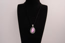 Raw Earth Crystals pink agate pendant with a teardrop-shaped design, featuring natural pink agate and an ornate silver-tone setting, promoting emotional balance, self-love, and gentle energy.