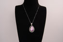 Raw Earth Crystals pink agate pendant with a teardrop-shaped design, featuring natural pink agate and an ornate silver-tone setting, promoting emotional balance, self-love, and gentle energy.