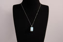 Raw Earth Crystals rectangle pendant featuring a polished opalite cabochon set in a sleek silver-toned bail, symbolizing serenity, emotional balance, and spiritual insight.