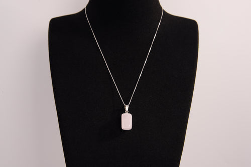 Raw Earth Crystals rectangle pendant featuring a polished rose quartz cabochon set in a sleek silver-toned bail, symbolizing love, compassion, and emotional healing.