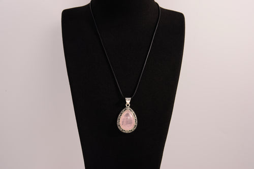 Raw Earth Crystals rose quartz pendant with a teardrop-shaped design, featuring natural rose quartz and an ornate silver-tone setting, promoting love, compassion, and emotional healing.