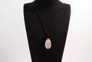 Raw Earth Crystals rose quartz teardrop pendant on black cord, crafted from natural rose quartz stone, promoting love, compassion, and emotional healing.