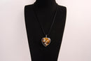 Raw Earth Crystals tiger eye heart pendant with an elegant rose design, featuring a rich golden-brown tiger eye stone and a silver-tone vine with leaves, promoting confidence, clarity, and personal power.