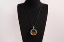 Raw Earth Crystals tiger eye pendant with a crystal-encased design, featuring natural tiger eye and gold-tone setting, supporting confidence, clarity, and personal power.