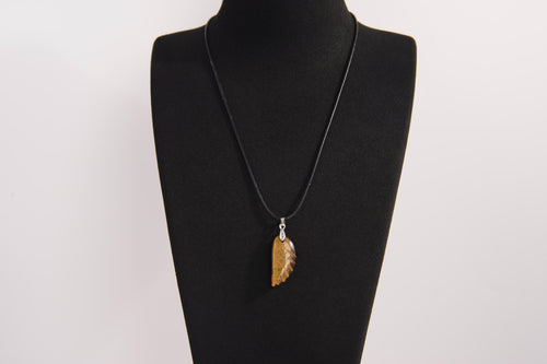 Raw Earth Crystals tiger eye pendant featuring an etched design, crafted from natural stone to promote balance, protection, and clarity.