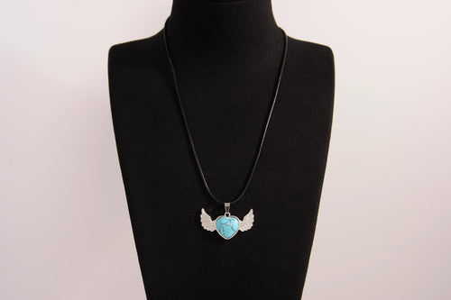 Raw Earth Crystals turquoise heart with wings necklace, featuring a vibrant blue-green heart-shaped stone adorned with delicate angelic wings, designed to promote communication, emotional balance, and spiritual protection.