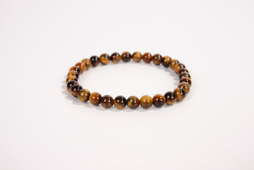 Tiger eye natural stone bead bracelet with polished round brown and gold beads on white background
